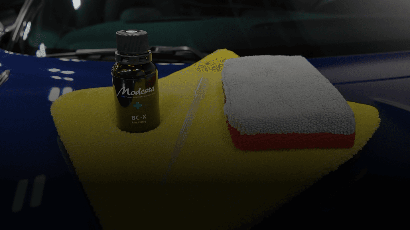 A car with a towel and cleaning supplies, showcasing Speed Shield USA's automotive detailing and protection services.