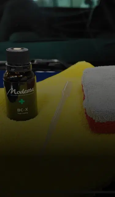 A car with a towel and cleaning supplies, showcasing Speed Shield USA's automotive detailing and protection services.