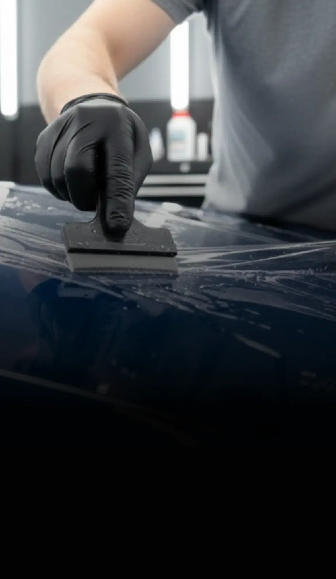 Installer wrapping a car in blue vehicle, highlighting Speed Shield USA's expertise in paint protection and vehicle wraps