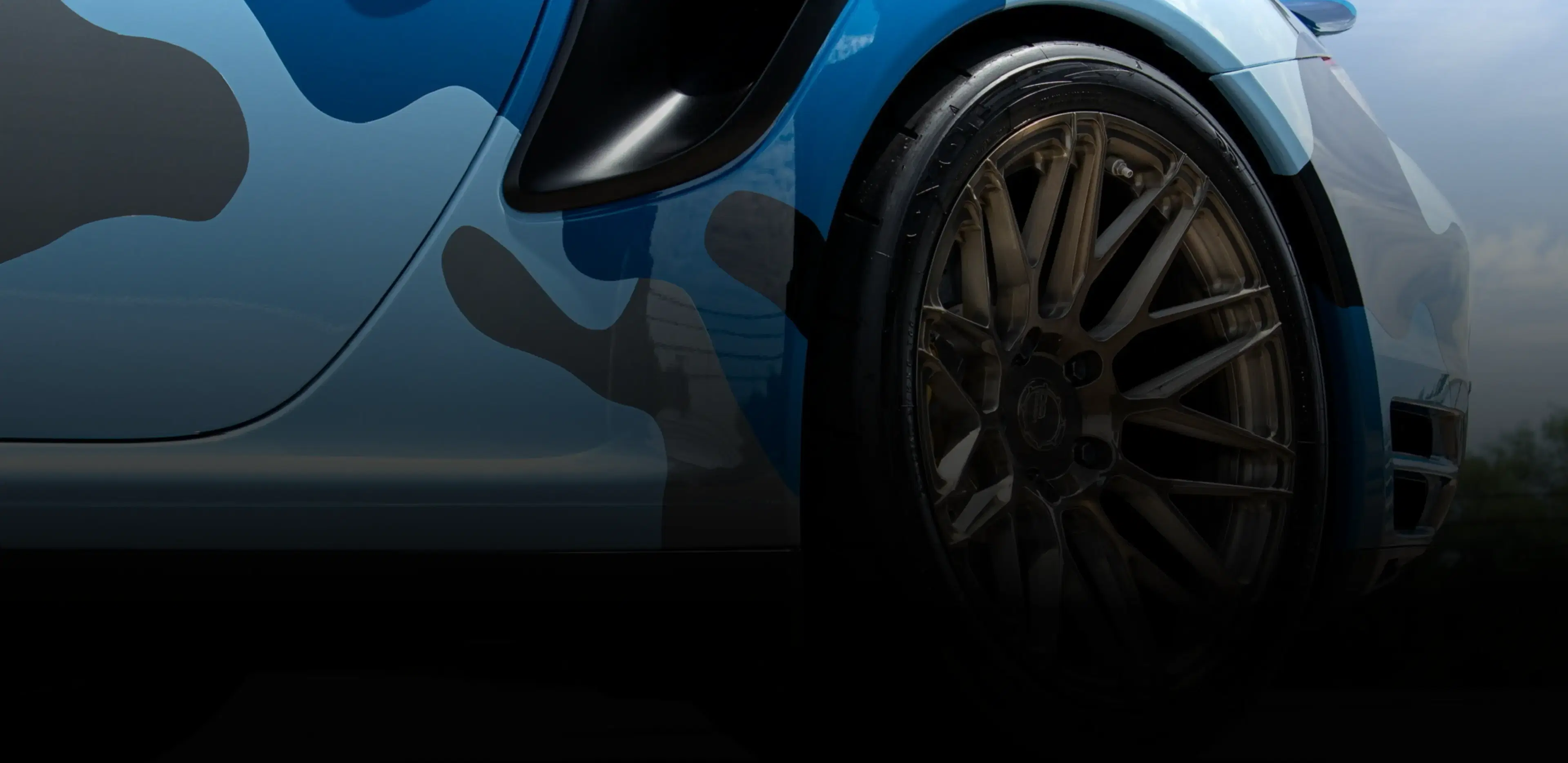 Installer wrapping a car in blue vinyl, highlighting Speed Shield USA's expertise in paint protection and vehicle wrap