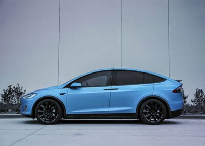 side view of a blue tesla